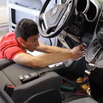 picture of a technician working on the driverside interior of the car