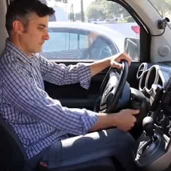 picture looking at man in the driver's seat of a car turning the ignition key
